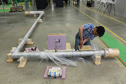 The 4 K liquid helium supply transfer line for the Vertical Test Area dewars was recently delivered to FRIB. Cryogenics Staff Engineer Chinh Nguyen removes packaging materials from the line.