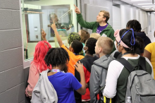 An FRIB staff member leads students on a tour of FRIB.