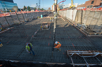 Workers place concrete for the lid of the linear accelerator tunnel. 