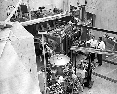 This photo shows the initial setup of the experimental area for the K50 cyclotron. The cyclotron itself is at the rear of the picture and the beamline and the second-hand Rochester scattering chamber are at the front. 