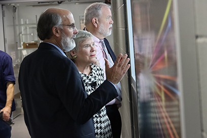 Pictured, from left: FRIB Scientific Director Bradley M. Sherrill, Rose Gottemoeller, and Sherman Garnett, former dean of MSU’s James Madison College. They are looking through a window inside of the FRIB Laboratory.