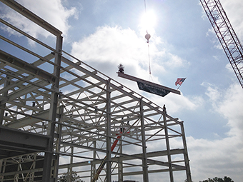 The final beam is put in place, signifying completion of the steel structure that will soon become the SRF Highbay