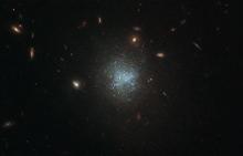 This Hubble Space Telescope image centers on what’s known as a low surface brightness, or LSB, galaxy (blue), surrounded by more familiar-looking galaxies (yellow). 